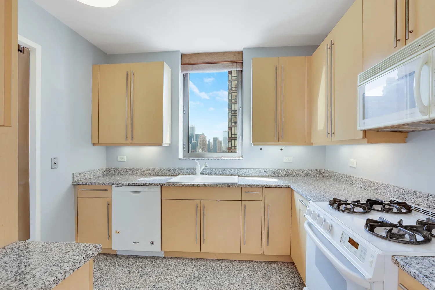 a kitchen with granite countertop a sink a stove and cabinets