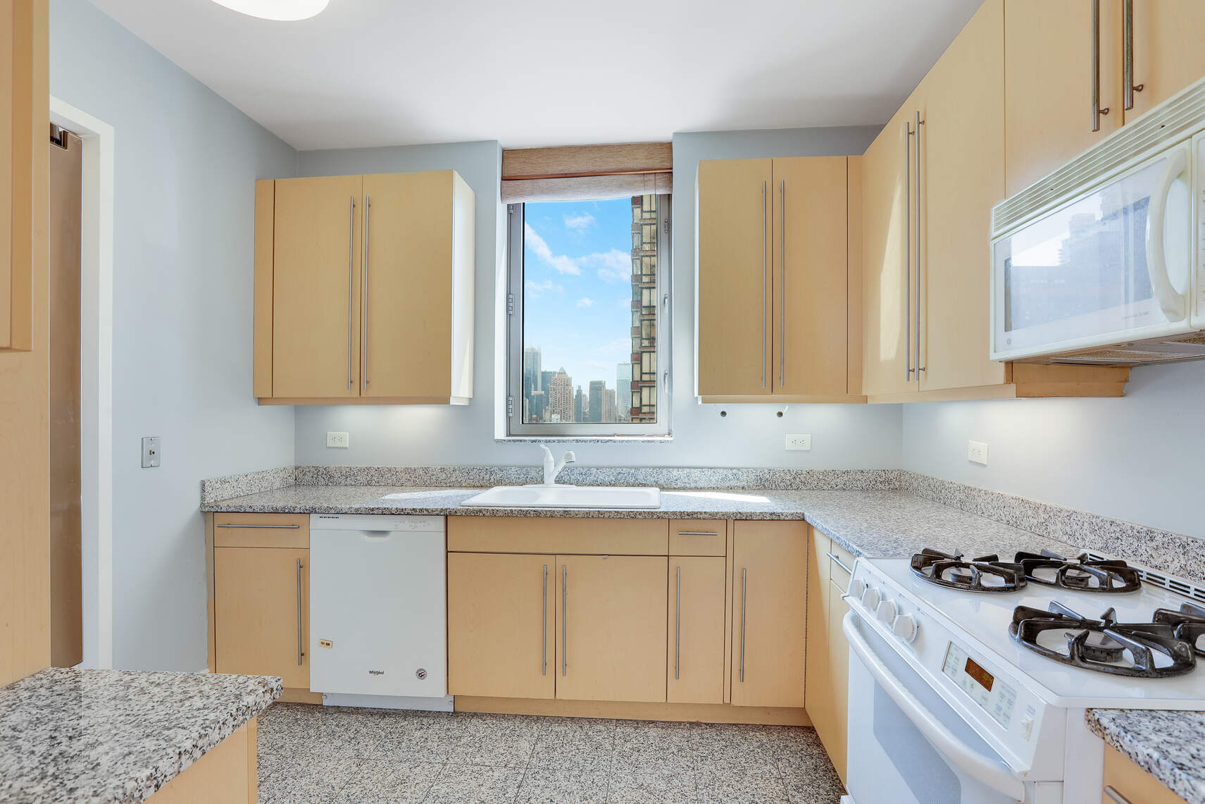 2 Columbus Avenue, Unit 17C Manhattan, NY 10023 - Photo 4 of 26 a kitchen with granite countertop a sink a stove and cabinets