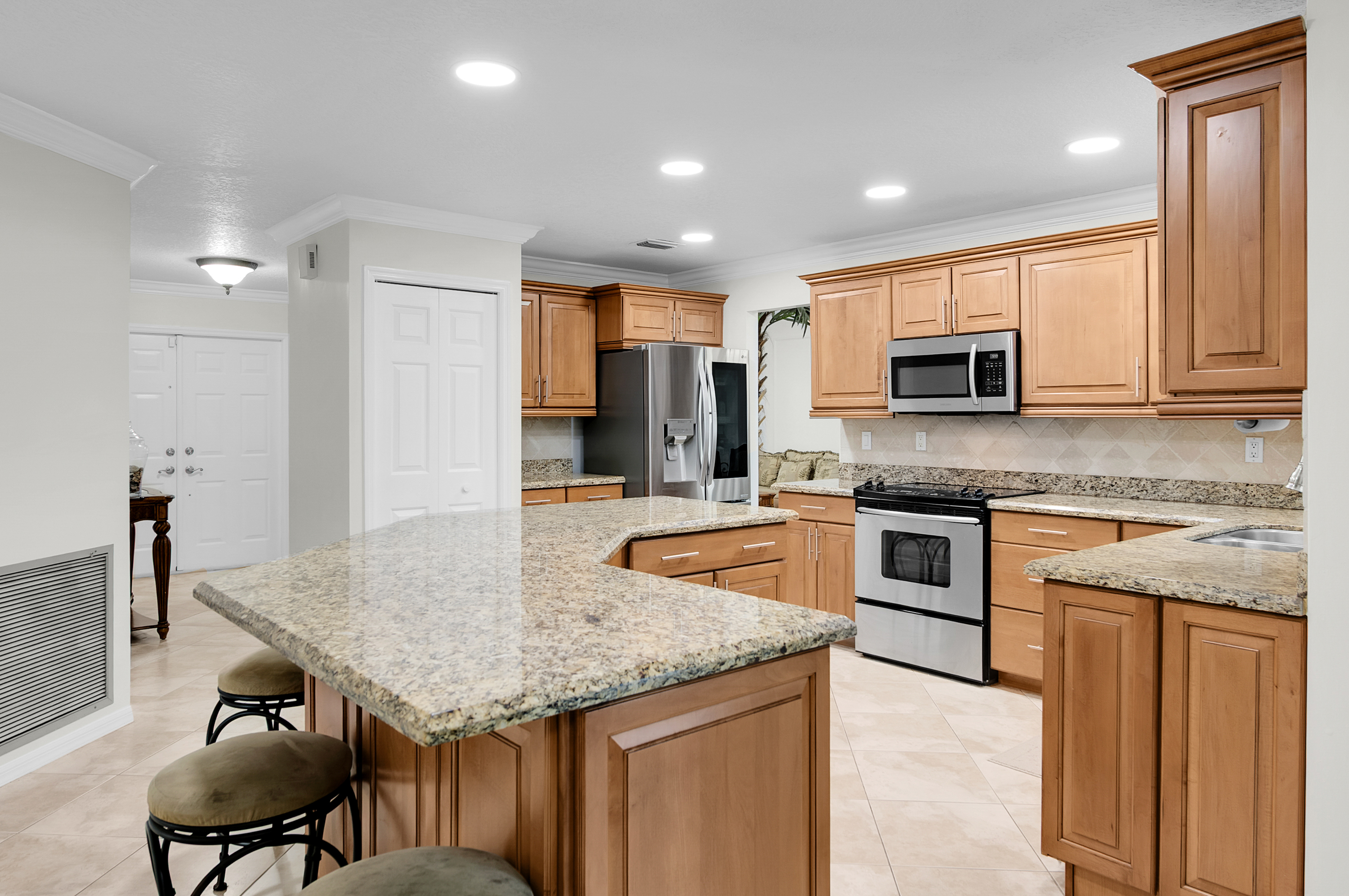 1560 Southwest 16th Street Boca Raton, FL 33486 - Photo 32 of 72 a kitchen with stainless steel appliances granite countertop a sink microwave and cabinets