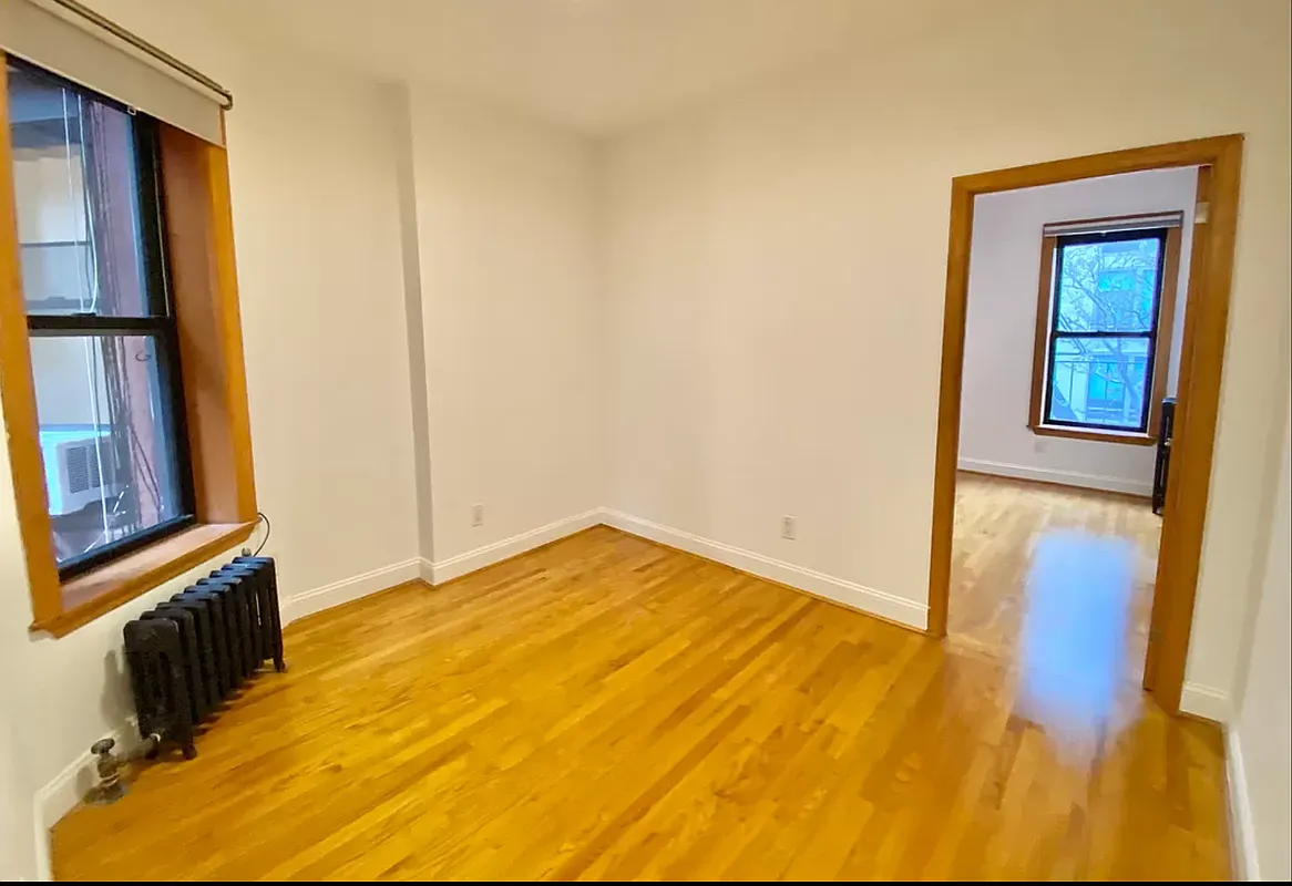 314 East 11th Street, Unit 3B Manhattan, NY 10003 - Photo 5 of 7 a view of an empty room with wooden floor and a window