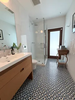 a bathroom with a sink a toilet a mirror and shower