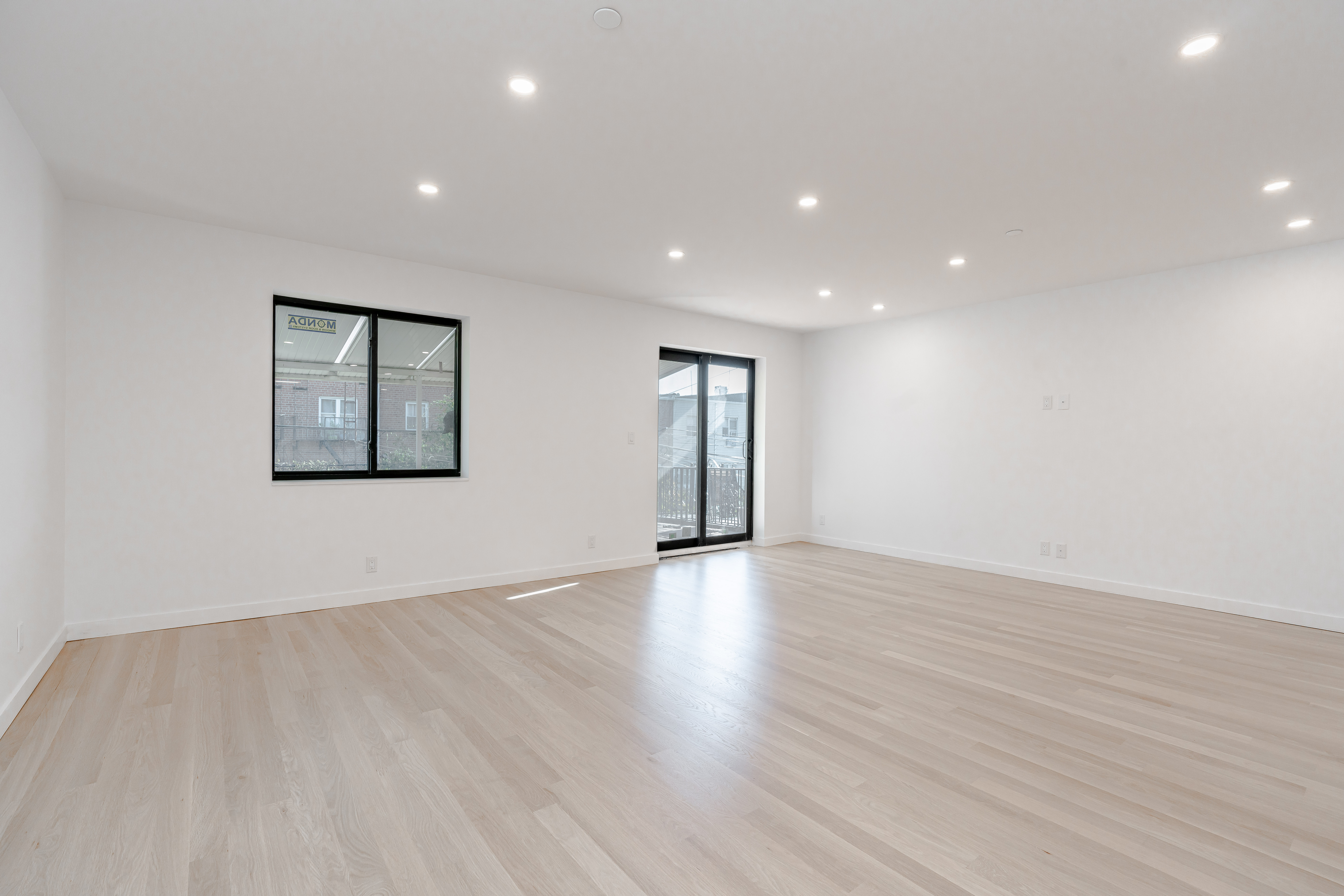 20-15 46th Street, Unit 2 Queens, NY 11105 - Photo 4 of 16 a view of an empty room with wooden floor and windows