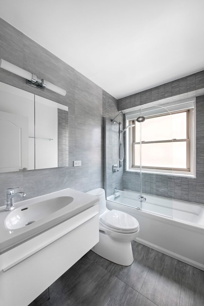 a bathroom with a bathtub toilet sink and mirror