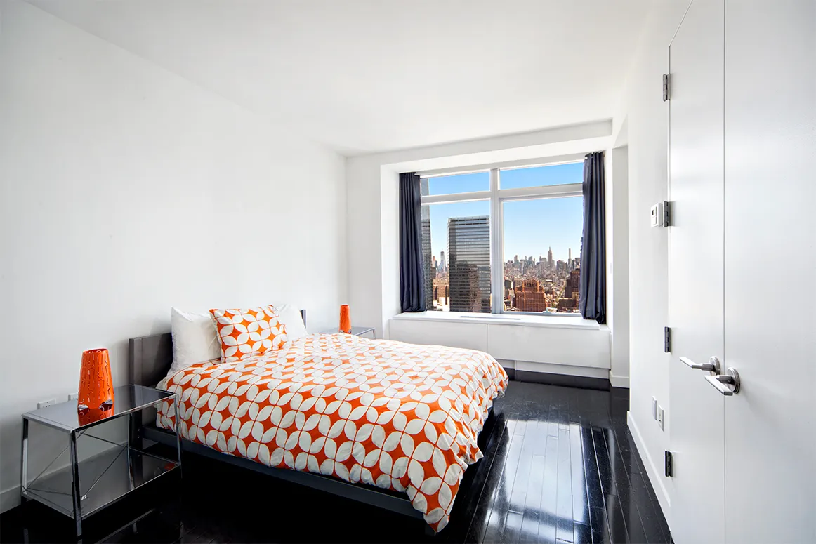 a bedroom with a bed and a large window