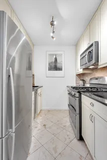 a kitchen with stainless steel appliances granite countertop a refrigerator and a stove top oven