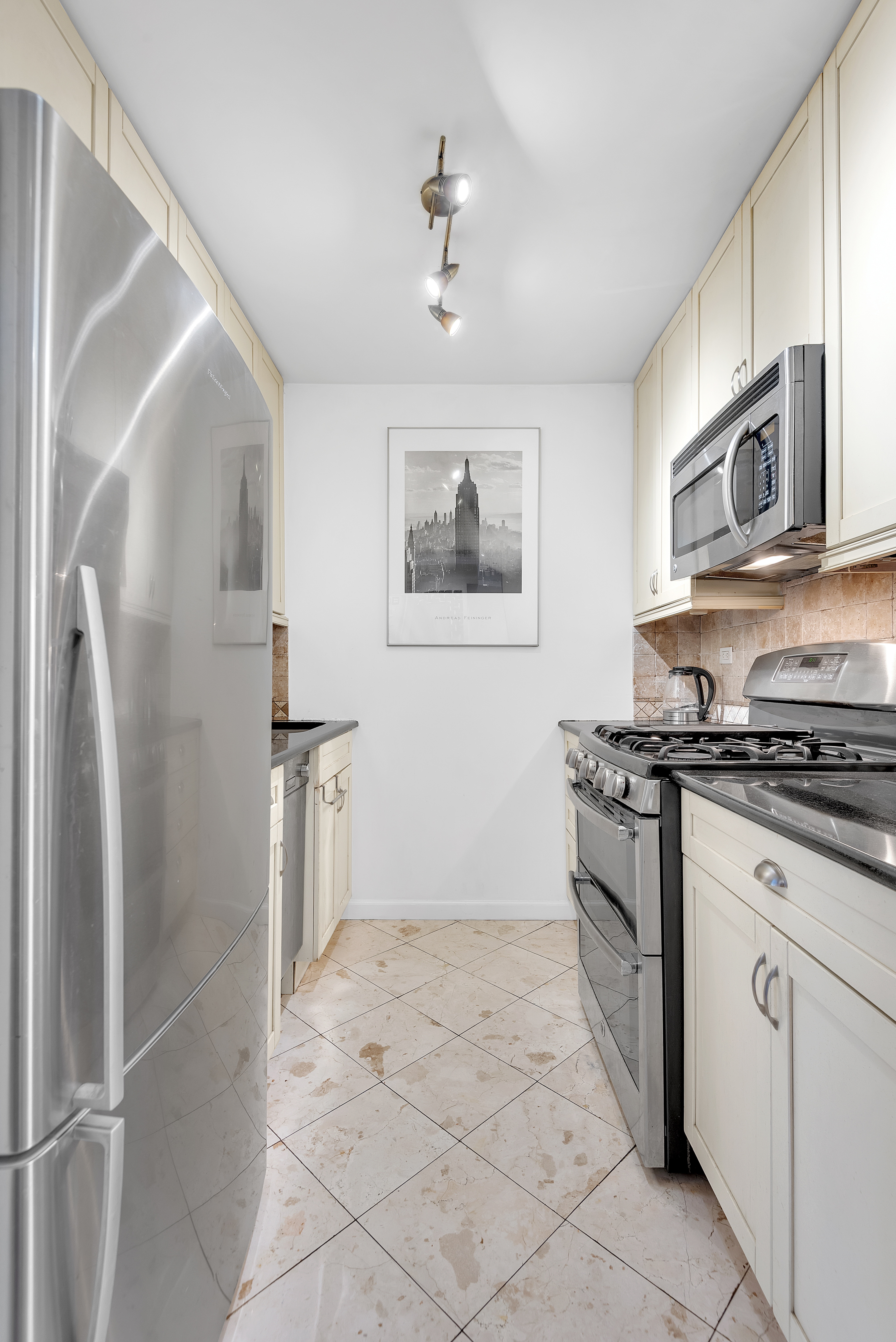 445 East 86th Street, Unit 6D Manhattan, NY 10028 - Photo 4 of 11 a kitchen with stainless steel appliances granite countertop a refrigerator and a stove top oven