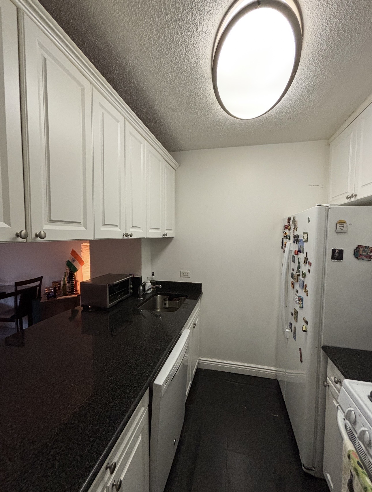 215 East 95th Street, Unit 19G Manhattan, NY 10128 - Photo 5 of 14 a kitchen with a sink a stove and cabinets