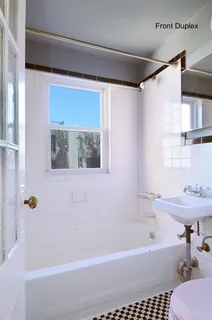 a bathroom with a bathtub a window and a shower