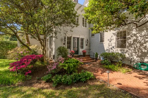a front view of a house with a yard and fountain