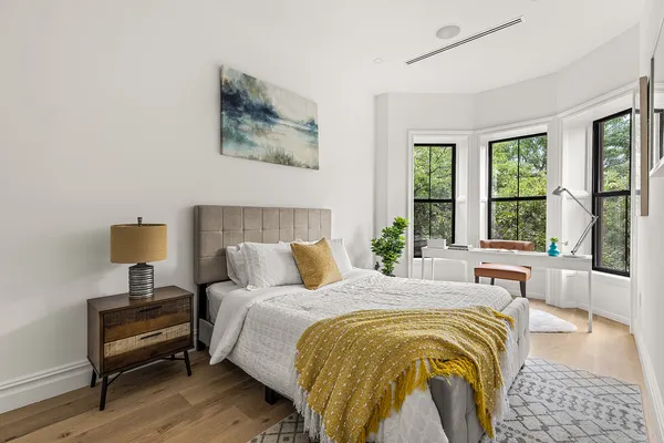a bedroom with a bed and wooden floor
