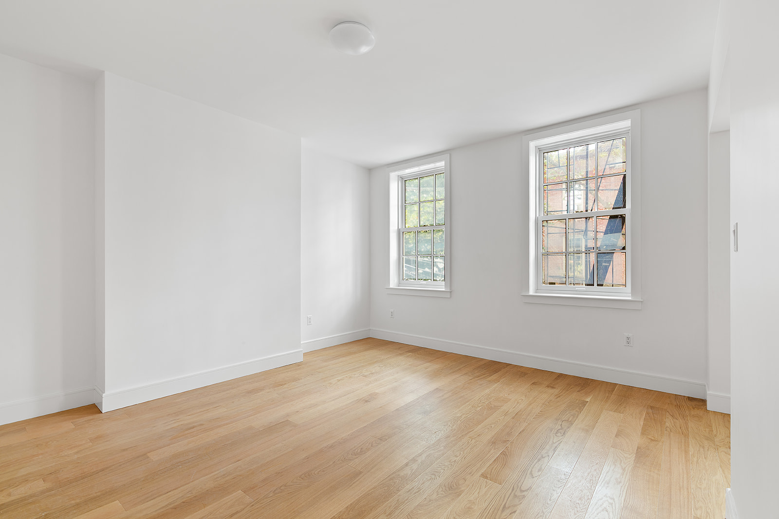 69 Hudson Avenue, Unit HSE Brooklyn, NY 11201 - Photo 17 of 20 an empty room with wooden floor and windows