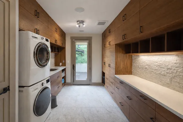 a bathroom with a granite countertop sink and a washing machine