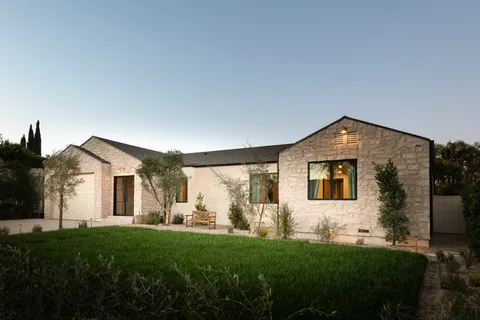 a front view of a house with a yard and trees