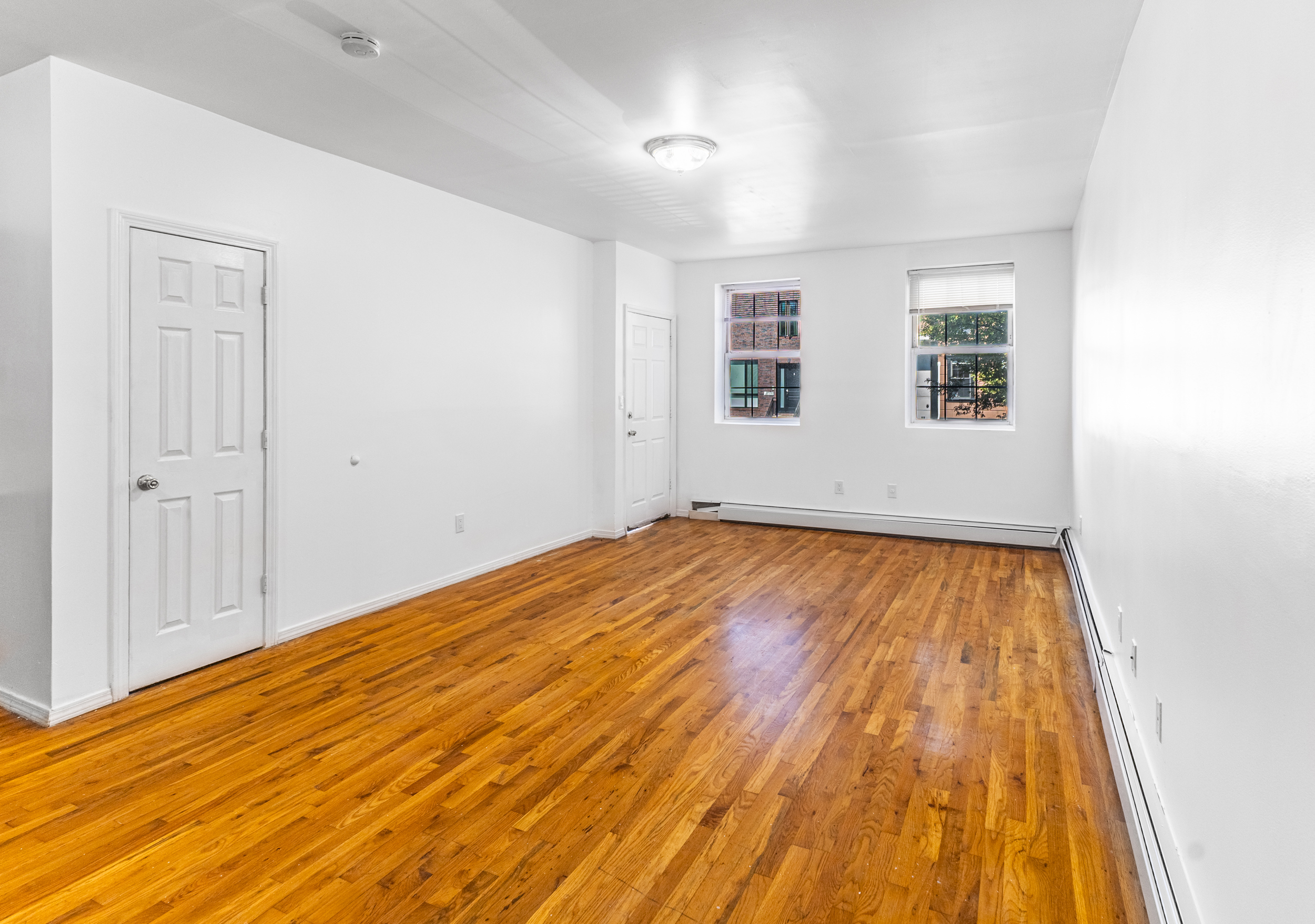 434 Lexington Avenue Brooklyn, NY 11221 - Photo 2 of 22 an empty room with wooden floor and windows