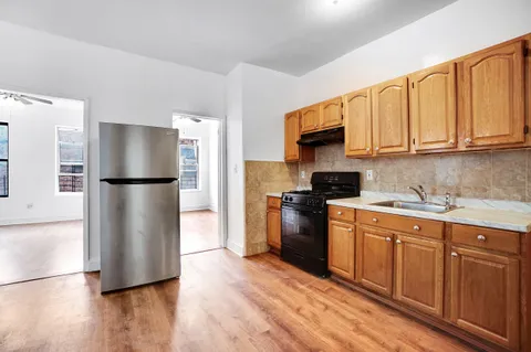 a kitchen with stainless steel appliances granite countertop a refrigerator a stove a sink and a microwave