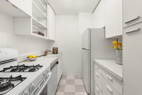 a kitchen with stainless steel appliances a stove a refrigerator and cabinets