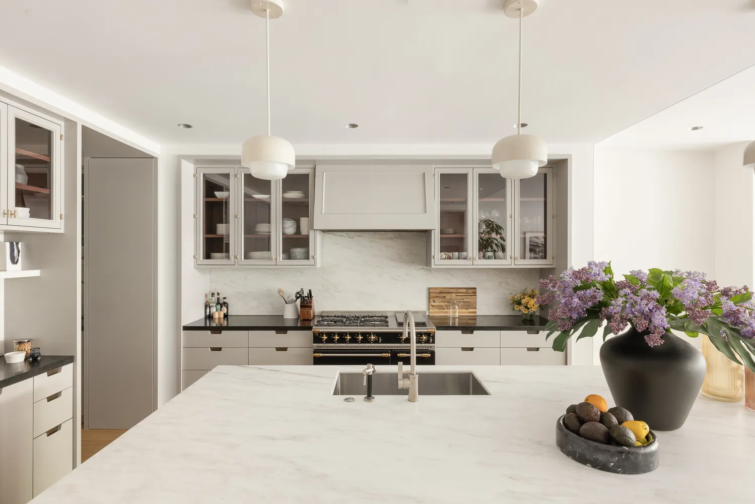 a kitchen with a sink and lots of white cabinets