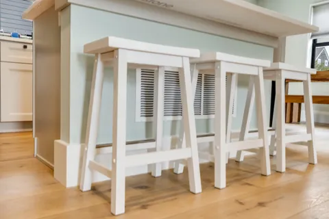 a white bed sitting in a room next to a window