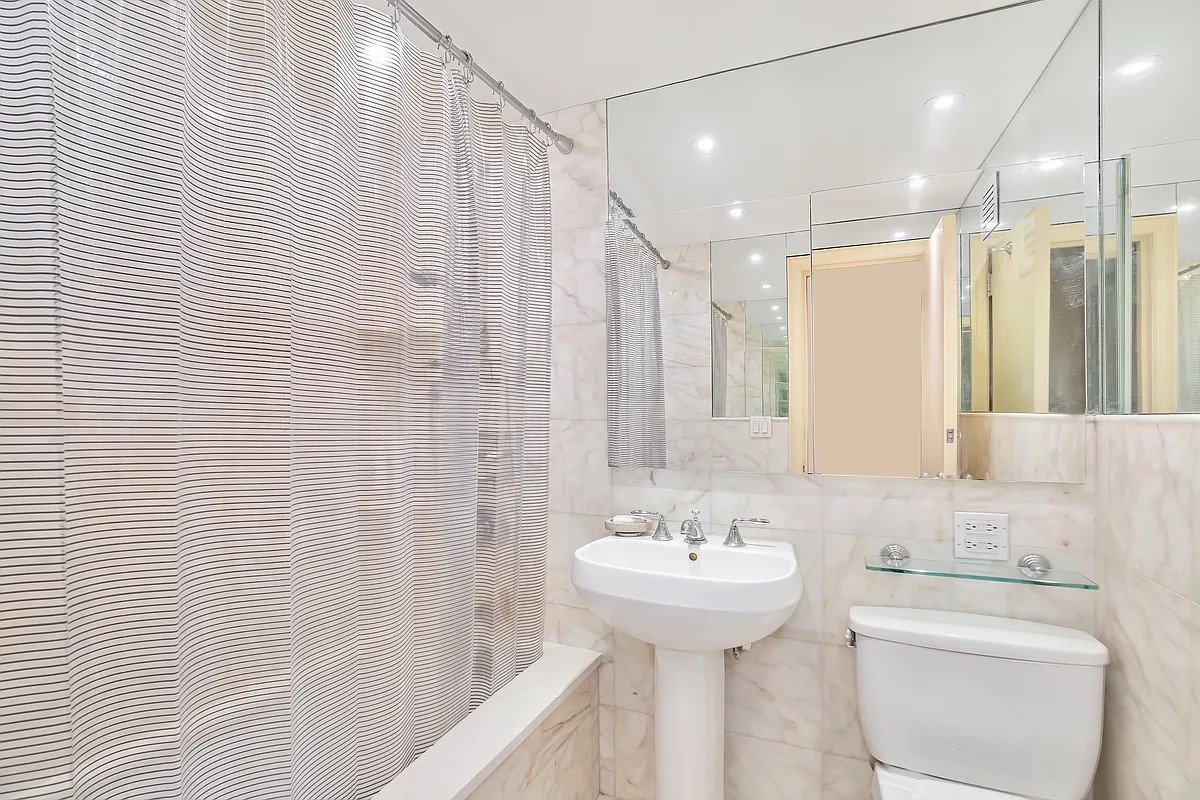 50 Sutton Place South, Unit 2D Manhattan, NY 10022 - Photo 4 of 11 a bathroom with a sink a toilet and shower