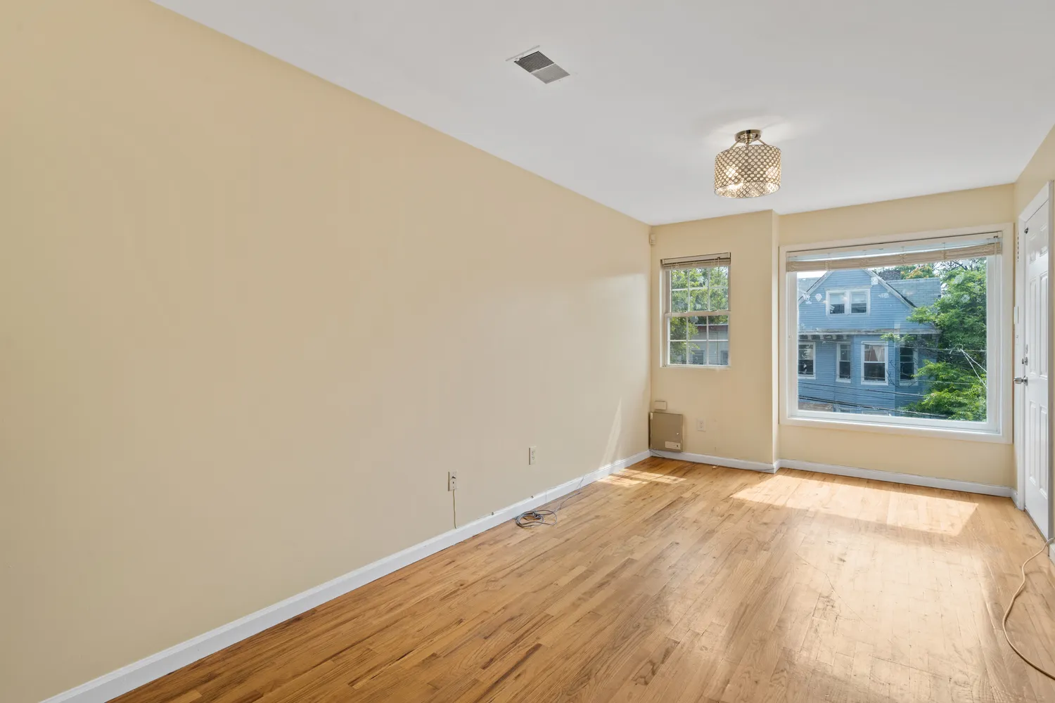 a view of empty room with wooden floor