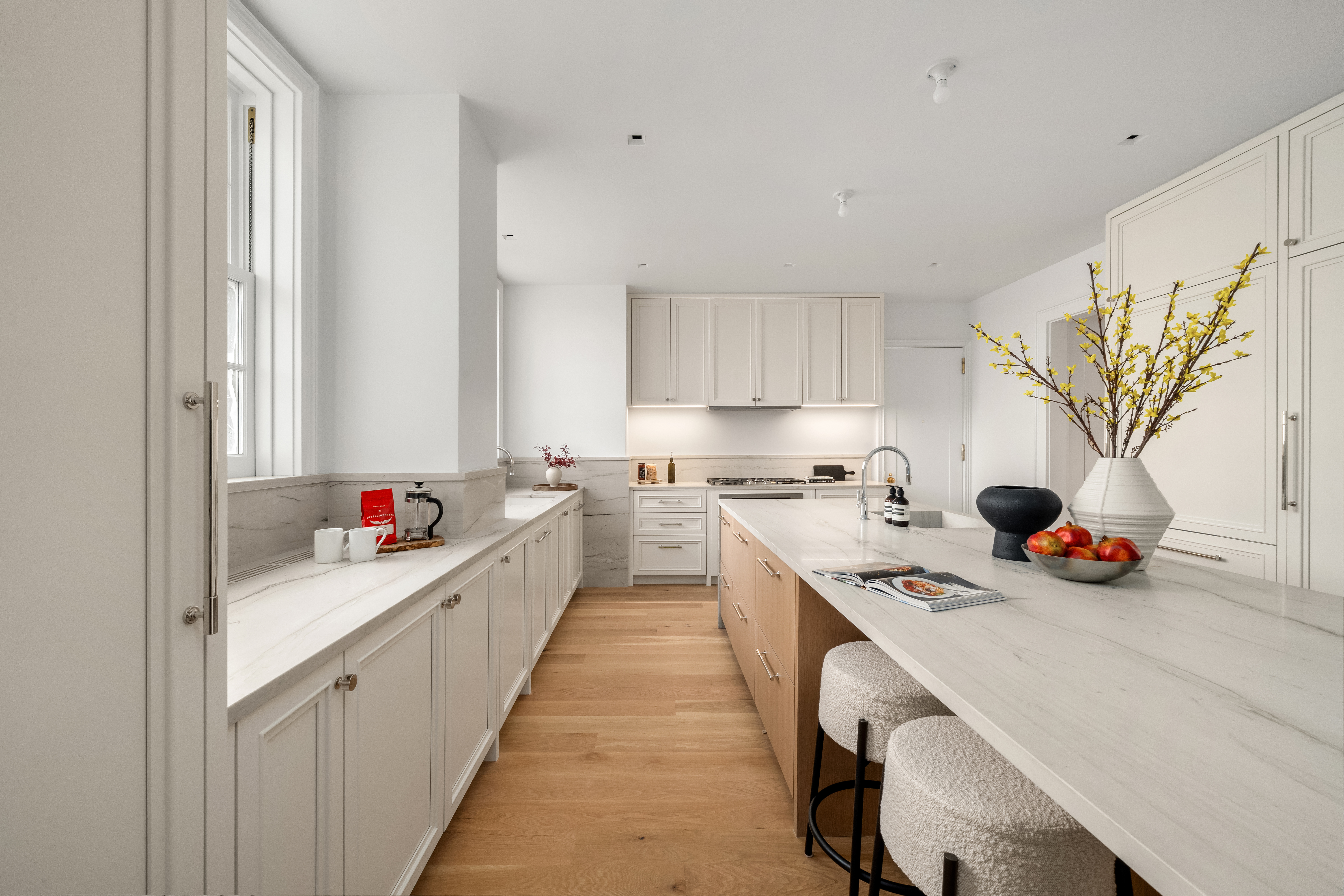 1020 5th Avenue, Unit 9 Manhattan, NY 10028 - Photo 9 of 27 a kitchen with stainless steel appliances a white stove top oven a sink a chimney and a center island