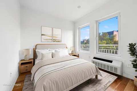 a bedroom with a bed and a large window