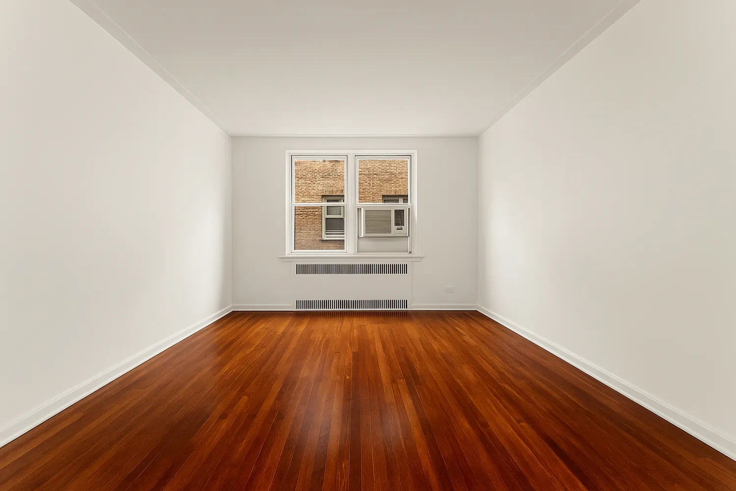 a view of an empty room with wooden floor and window