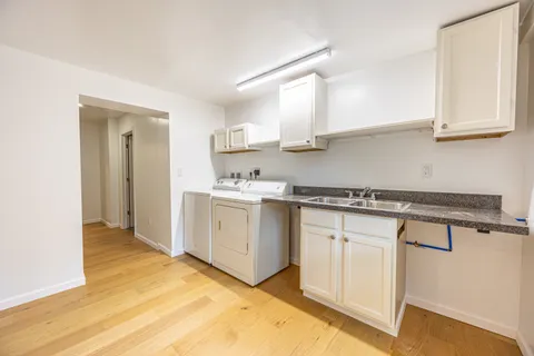 a kitchen with granite countertop white cabinets and white appliances