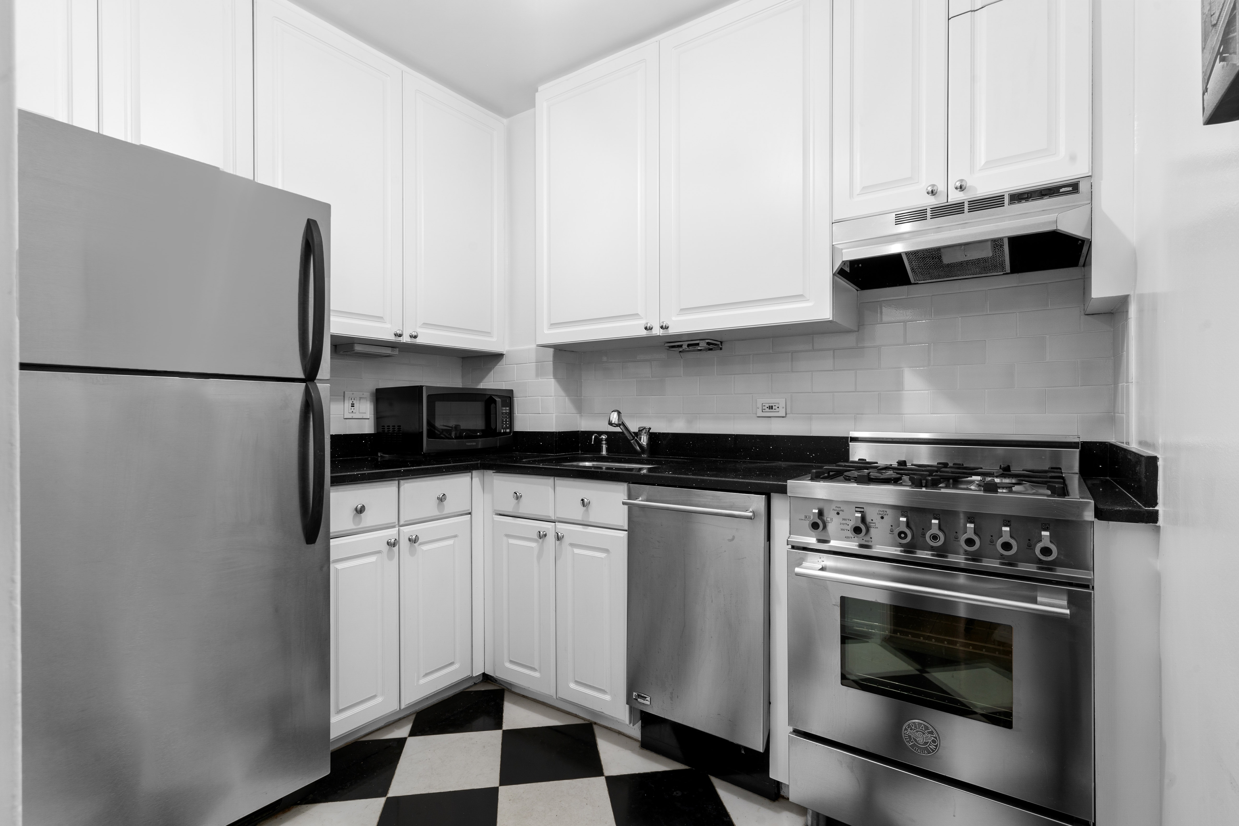55 East 87th Street, Unit 5M Manhattan, NY 10128 - Photo 7 of 10 a kitchen with white cabinets and appliances