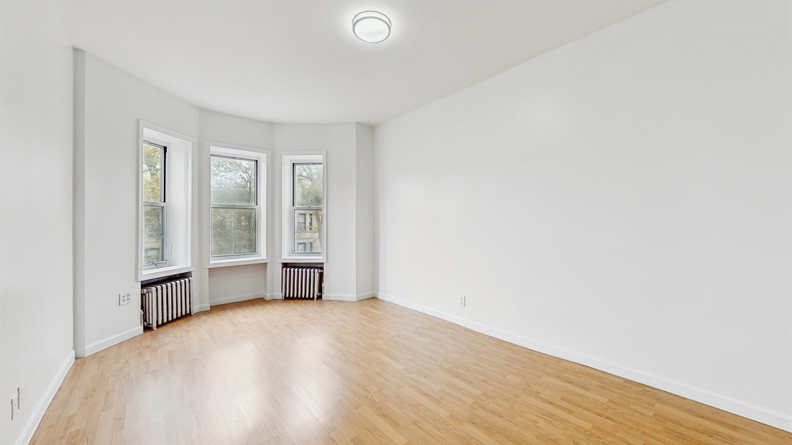 454 77th Street, Unit 3 Brooklyn, NY 11209 - Photo 5 of 25 a view of an empty room with wooden floor and a window