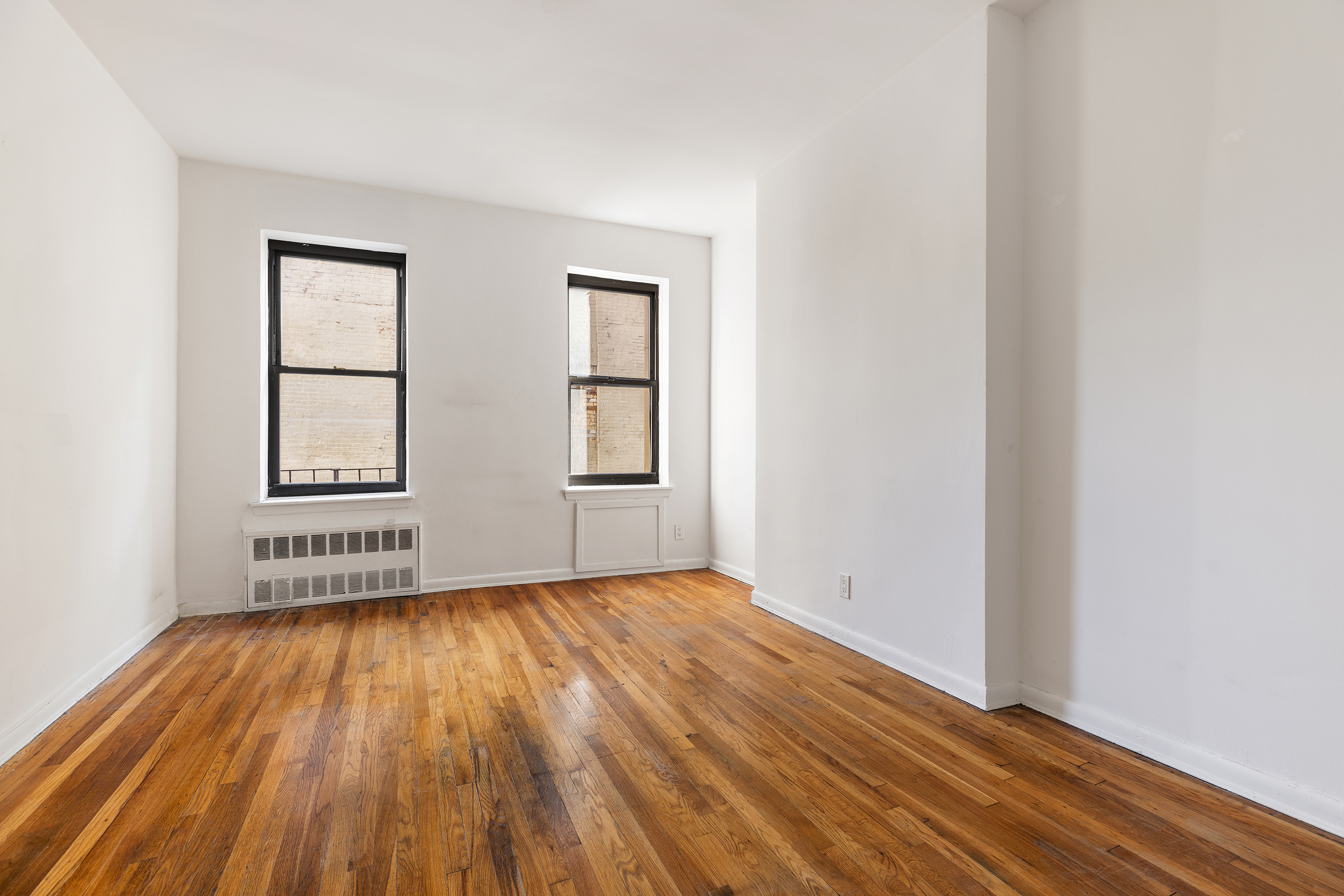 1275 3rd Avenue, Unit 4A Manhattan, NY 10021 - Photo 5 of 8 an empty room with wooden floor and windows