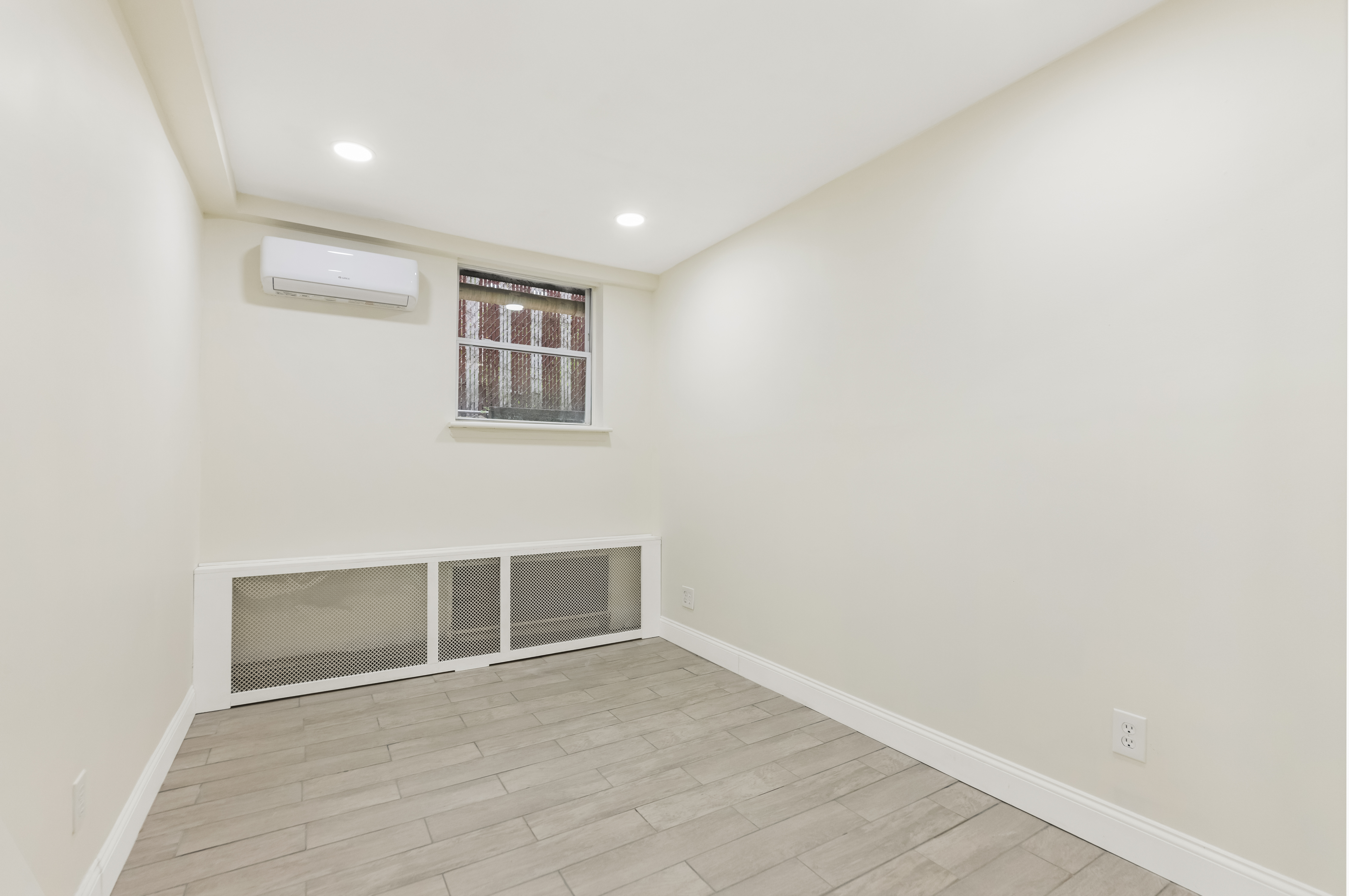 185 Oxford Street Brooklyn, NY 11235 - Photo 7 of 17 an empty room with wooden floor and windows