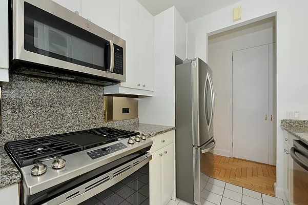 845 United Nations Plaza, Unit 56E Manhattan, NY 10017 - Photo 12 of 28 a kitchen with a stove and a microwave
