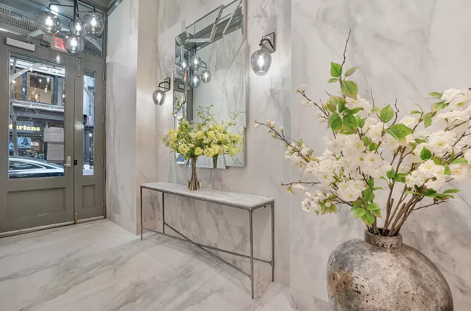 145 Spring Street, Unit 6 Manhattan, NY 10012 - Photo 1 of 1 a white vase with white and yellow flowers