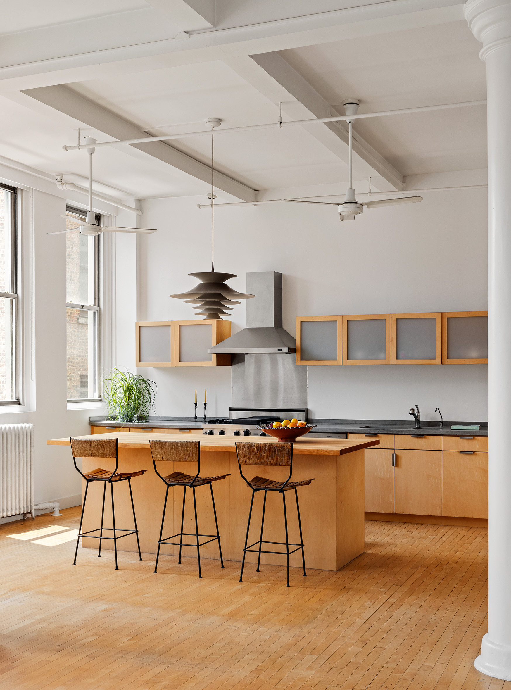 32 West 20th Street, Unit 9B Manhattan, NY 10011 - Photo 4 of 16 a kitchen with stainless steel appliances granite countertop a table chairs stove and cabinets