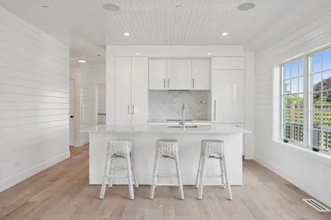 a kitchen with stainless steel appliances white cabinets and wooden floor