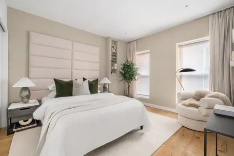 a bedroom with bed and a potted plant