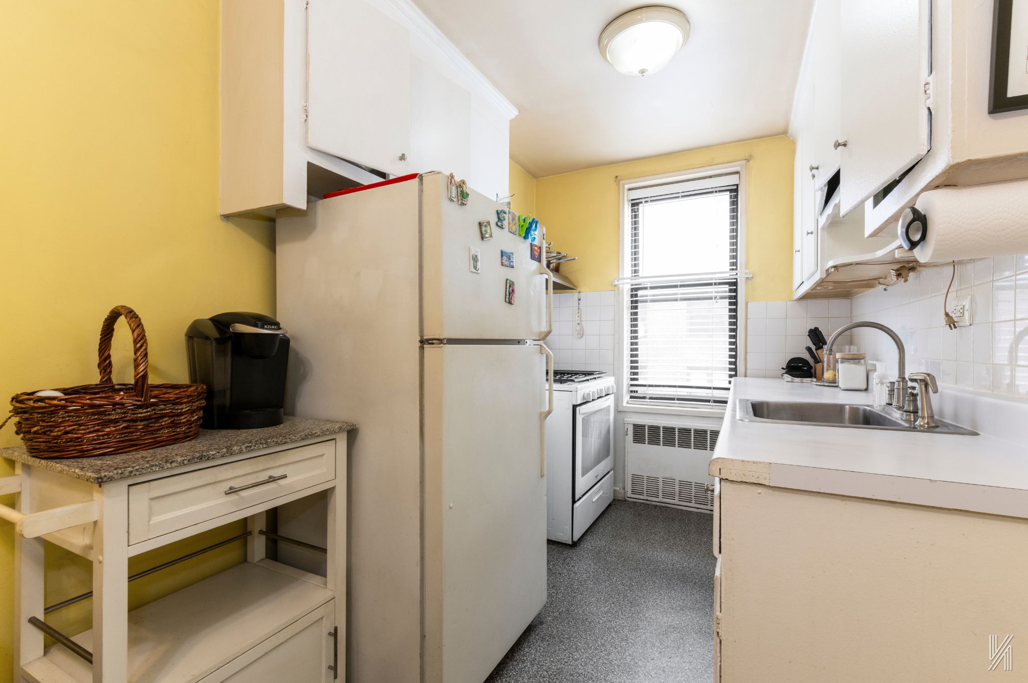 33-27 91st Street, Unit 3J Queens, NY 11372 - Photo 5 of 13 a kitchen with white cabinets and appliances