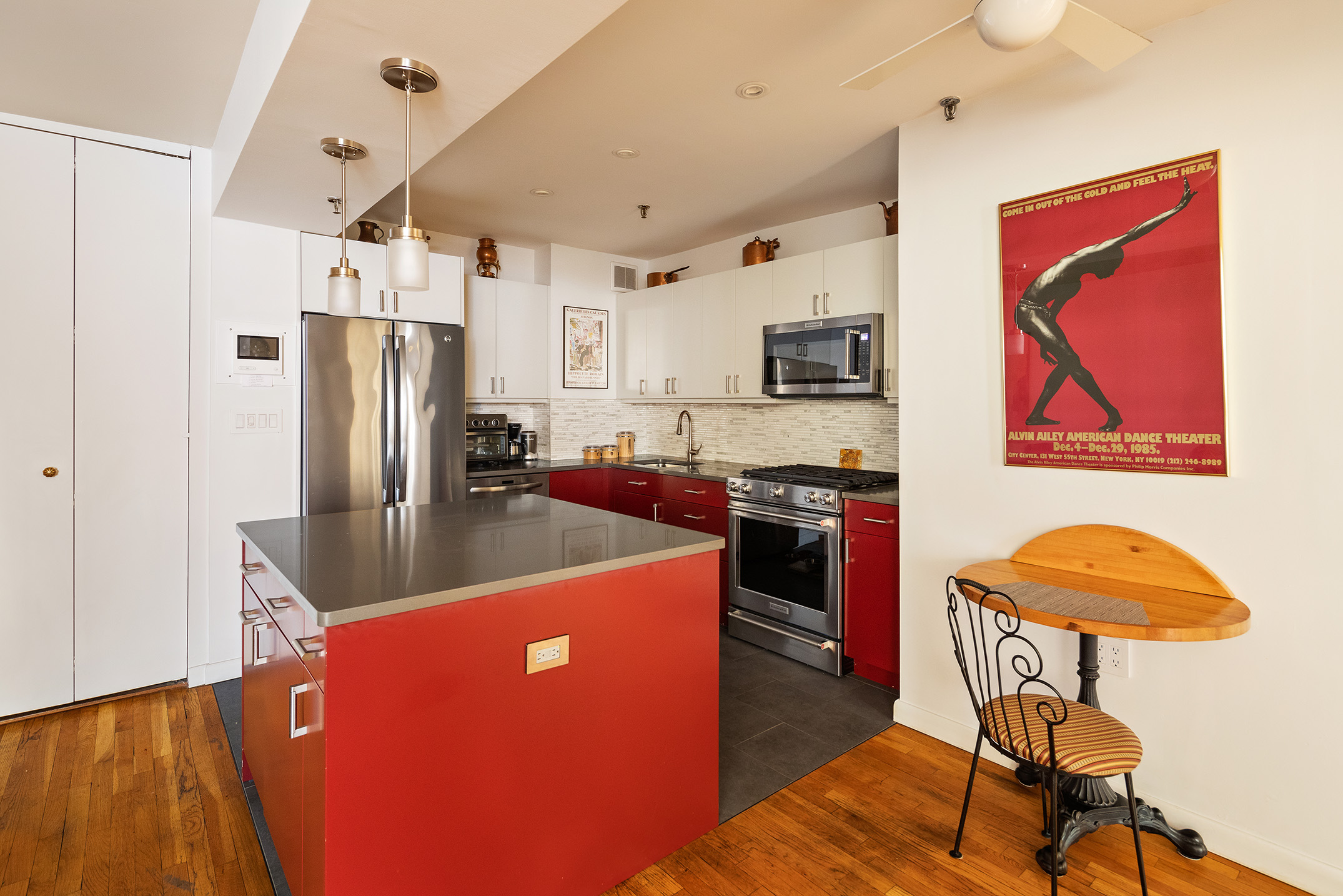 240 West 23rd Street, Unit 5A Manhattan, NY 10011 - Photo 3 of 7 a kitchen with stainless steel appliances granite countertop a refrigerator a stove a sink dishwasher a dining table and chairs with wooden floor