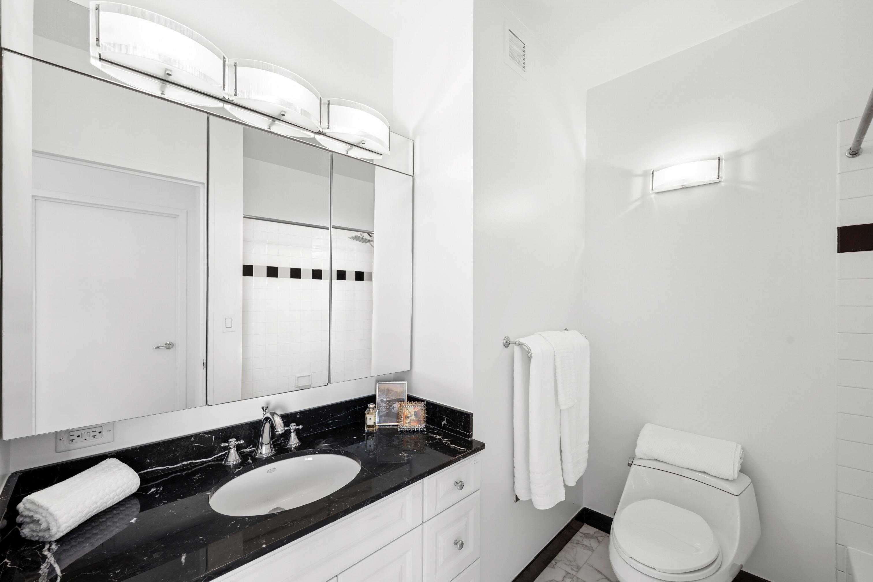 111 West 67th Street, Unit 22B Manhattan, NY 10023 - Photo 5 of 10 a bathroom with a sink a toilet a mirror and shower