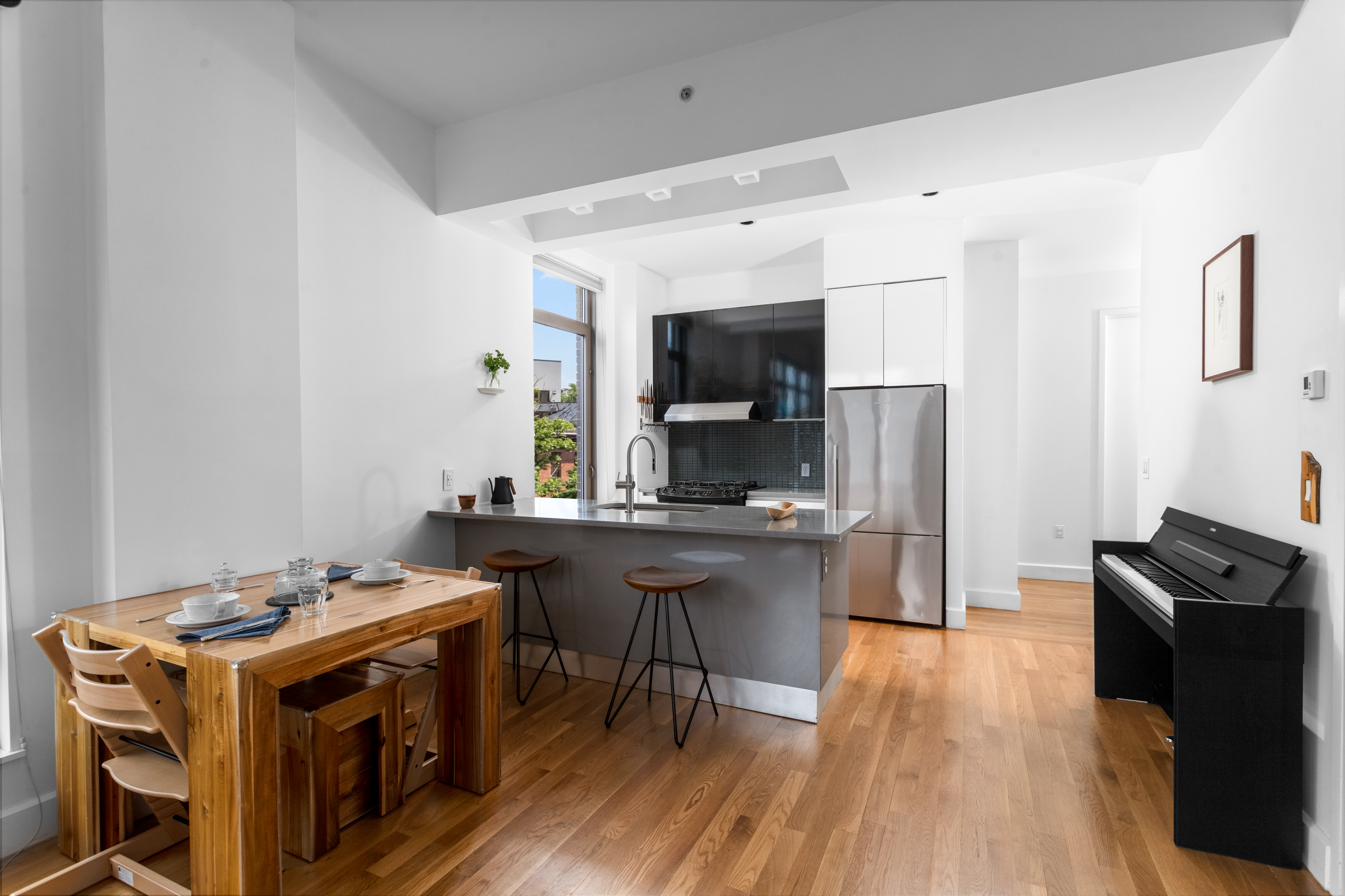 315 Gates Avenue, Unit 4E Brooklyn, NY 11216 - Photo 5 of 17 a open kitchen with stainless steel appliances a stove a refrigerator a sink dishwasher and a stove with wooden floor