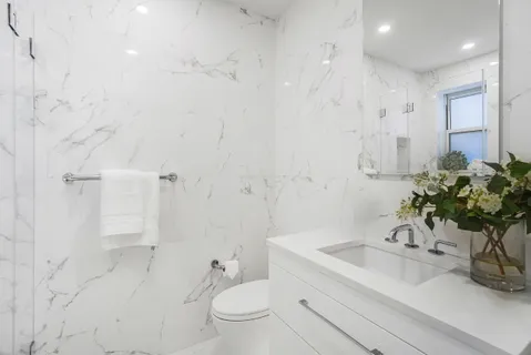 a bathroom with a sink a toilet and shower