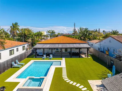 a view of a swimming pool with lawn chairs under an umbrella