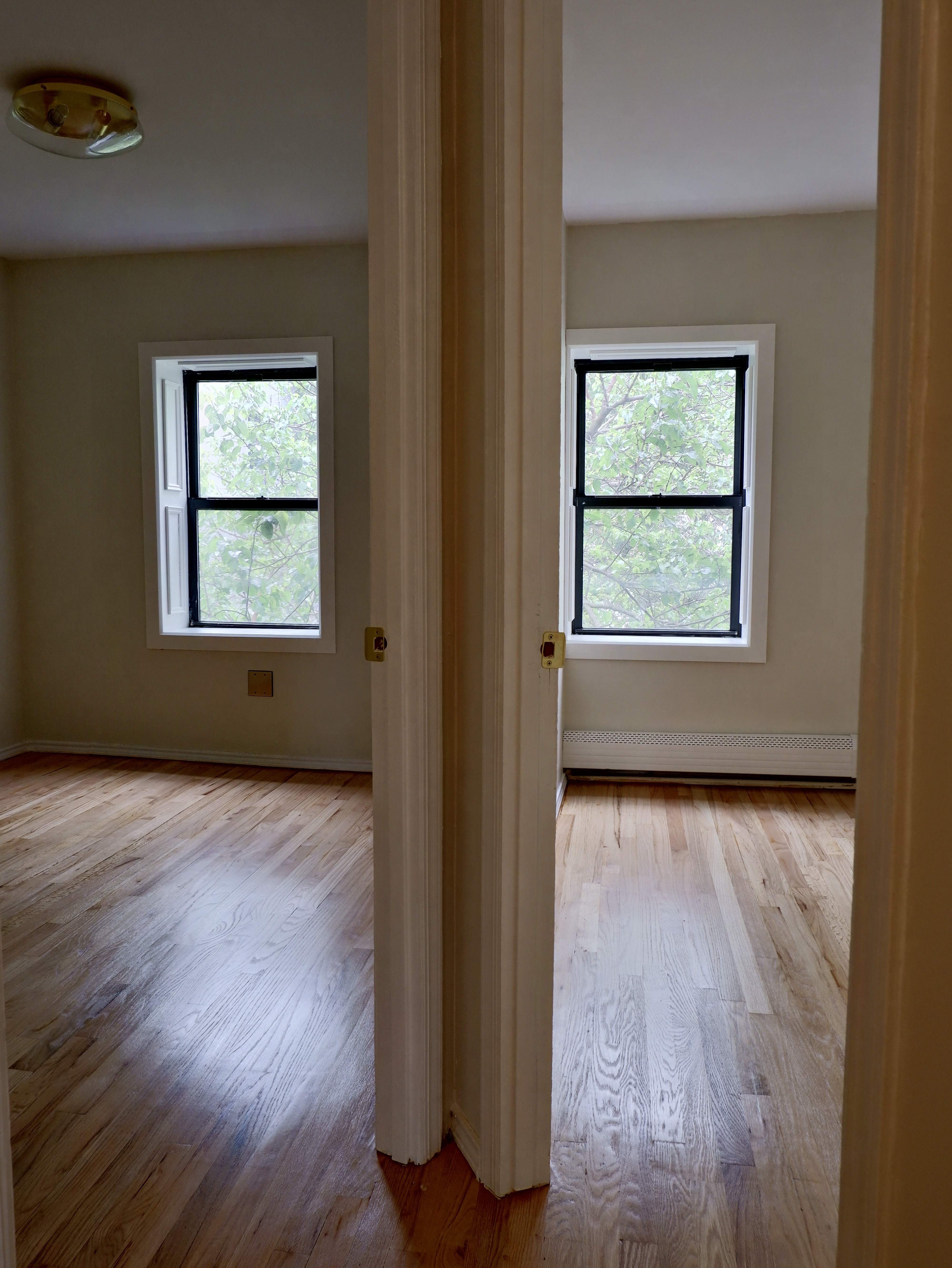 132 Decatur Street, Unit 3 Brooklyn, NY 11216 - Photo 12 of 17 an empty room with wooden floor and windows
