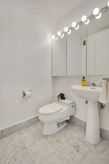 a bathroom with a sink toilet and a mirror