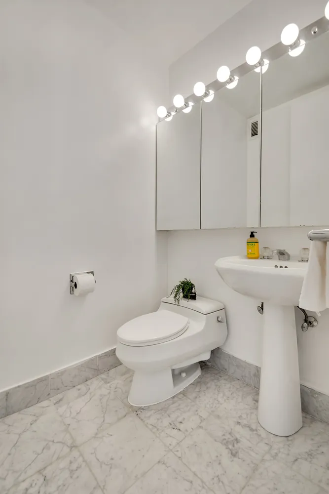 a bathroom with a sink toilet and a mirror