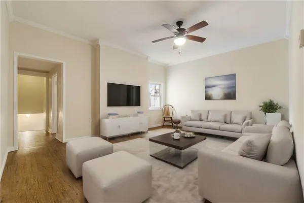 a living room with furniture kitchen view and a flat screen tv