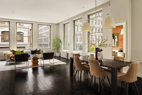 a living room with furniture and floor to ceiling windows