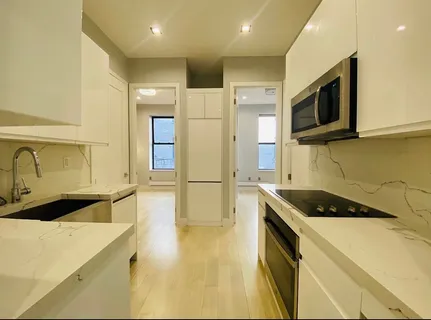 a kitchen with stainless steel appliances a stove a microwave a sink and cabinets