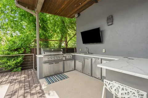 a backyard of a house with wooden floor barbeque oven and outdoor seating